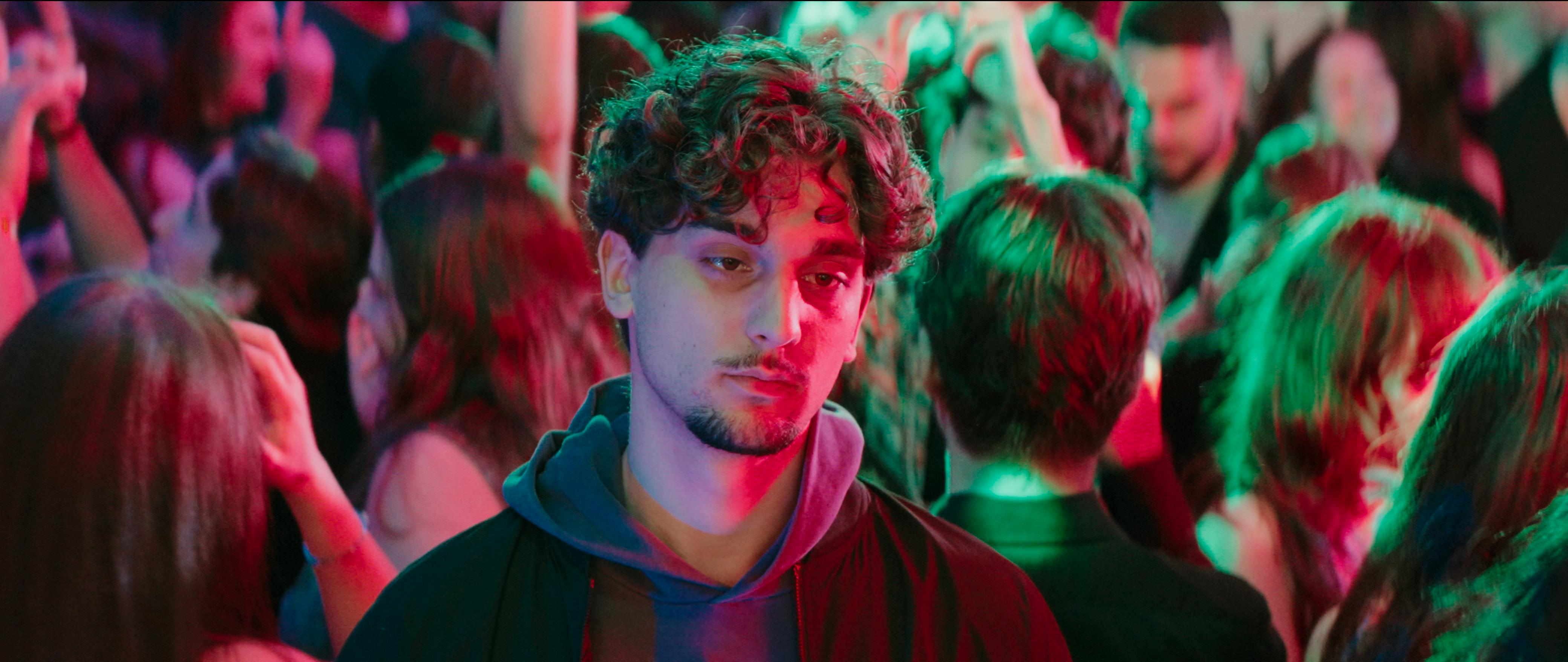 Janosch alone in a crowded club