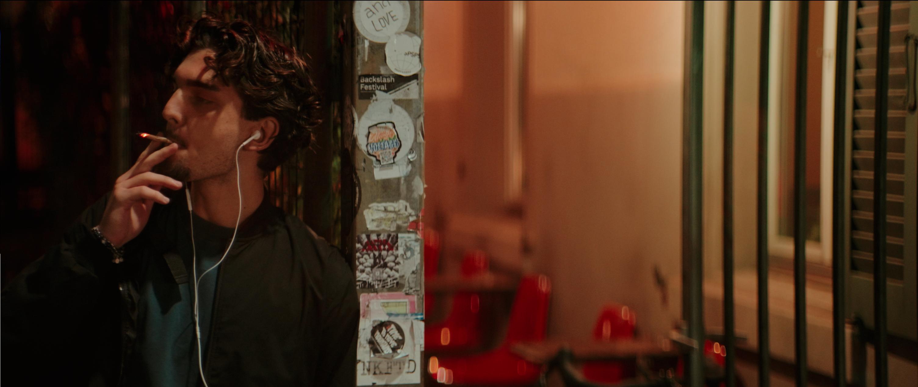 Janosch smoking in an alley