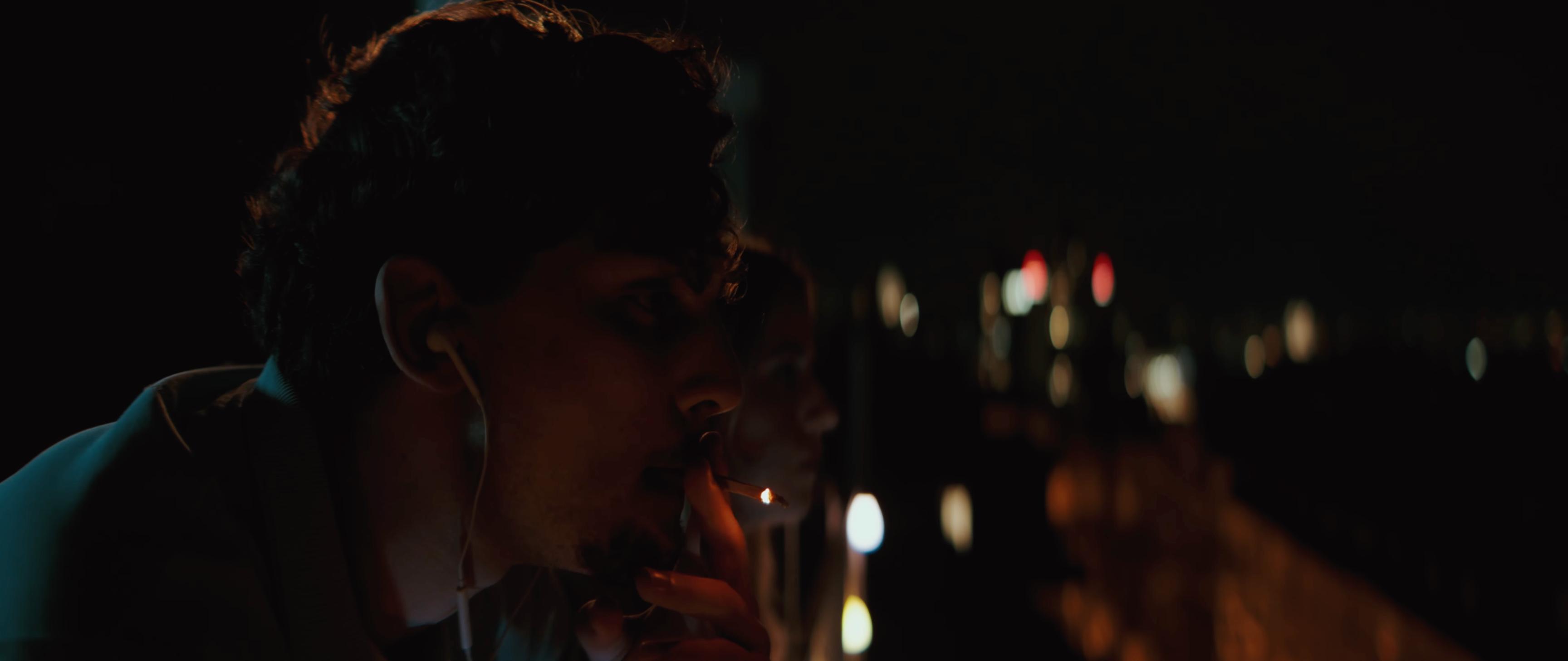 Janosch smoking, close-up at night